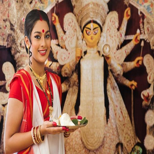 Bengali woman holding a puja thali at Durga Puja